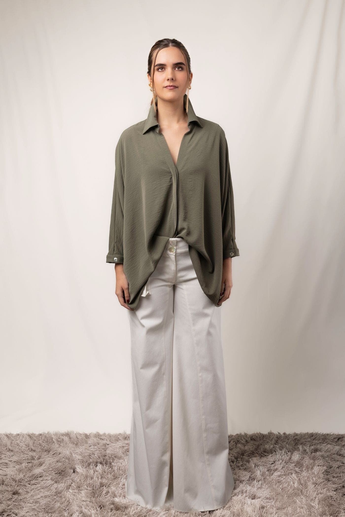 Modelo con pantalón marfil con pinzas y camisa verde oliva