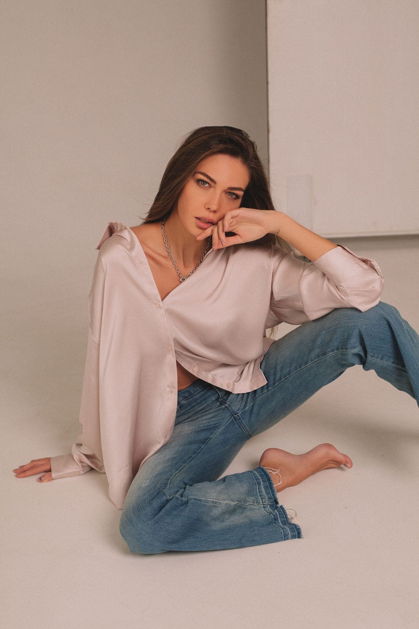 Modelo con blusa de satén rosa empolvado y jean claro